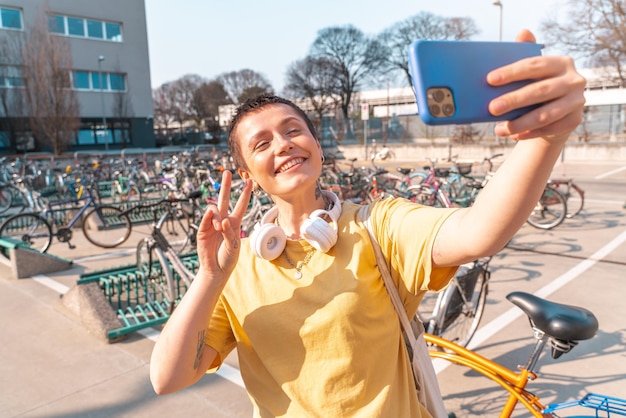 Frau macht ein Selfie mit Handy auf einem Fahrradparkplatz