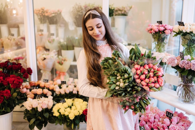 Frau macht Frühlingsblumenstrauß weibliche Floristin hält Blumenstrauß aus Frühlingsblumen schöne Blumenzusammensetzung