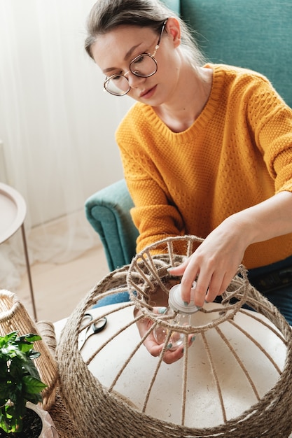 Frau macht handgemachte DIY-Lampe aus Juteseil