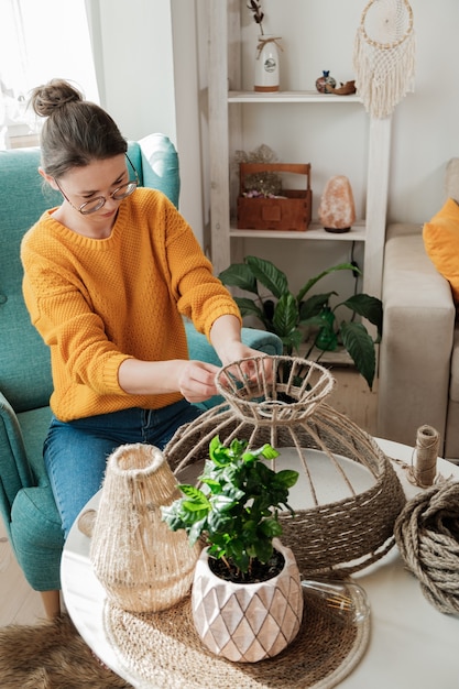 Frau macht handgemachte DIY-Lampe aus Juteseil