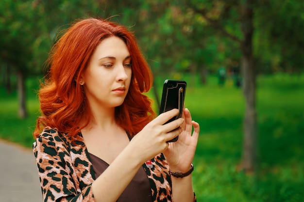 Frau macht mobiles Foto im Wald