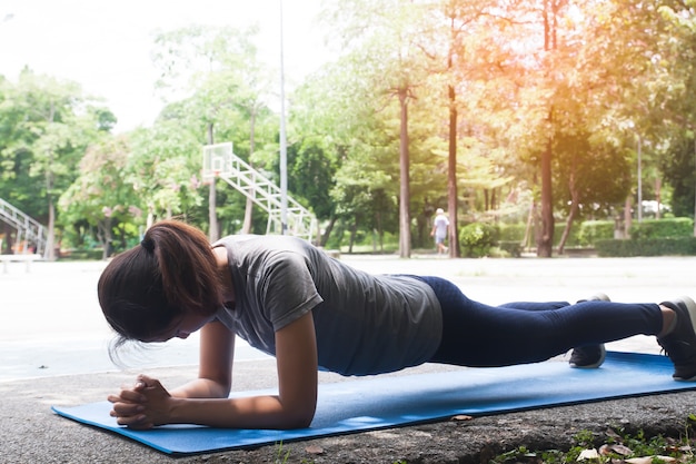 Frau macht Planke auf Yogamatte