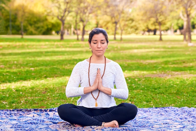 Frau macht Reiki und Yoga-Pose in einer Park-Chakra-Pose