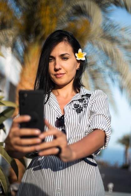 Frau macht Selfie in der Nähe von Palme