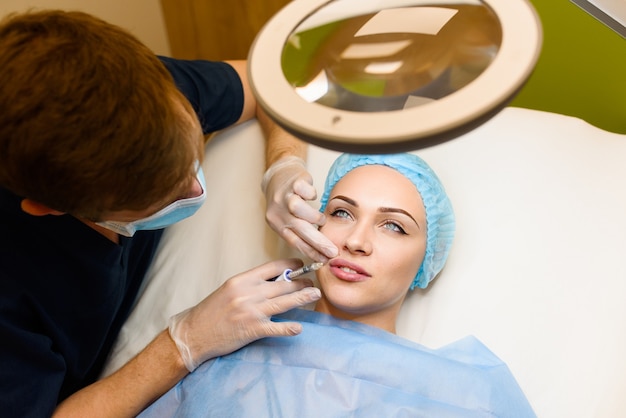 Frau macht verjüngende Gesichtsinjektionen Verfahren zur Lippenvergrößerung