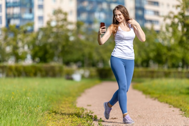 Frau macht Videoanruf per Telefon im Stadtgarten