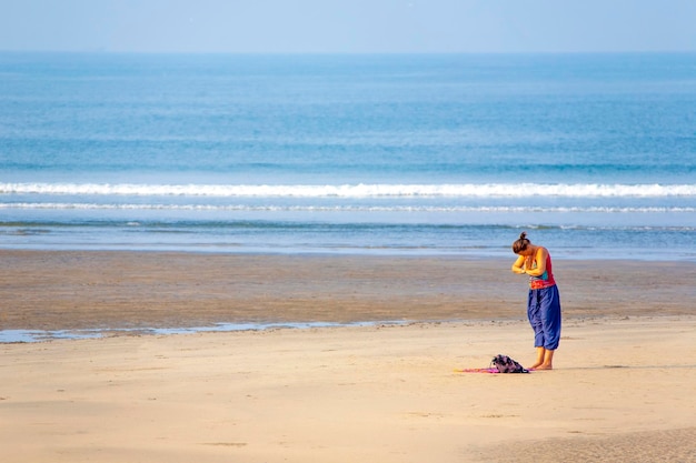 Frau macht Yoga am Strand