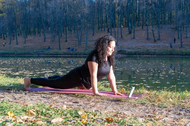 Frau macht Yoga auf Matte im Freien