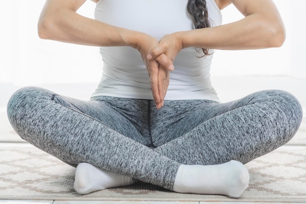 Frau macht Yoga drinnen Nahaufnahme macht tiefe Meditationshaltungen