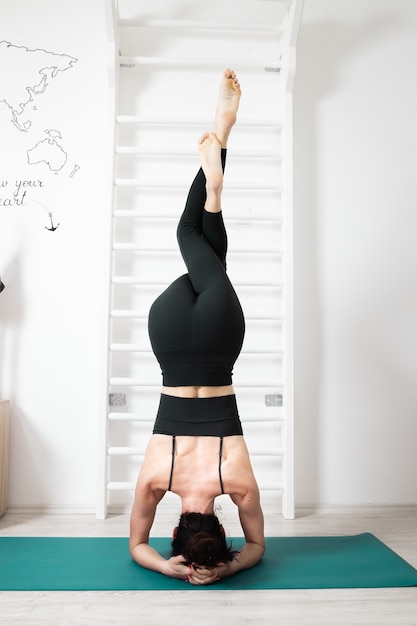 Frau macht Yoga in ihrem Haus
