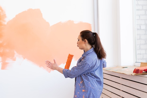 Frau malt die Wand