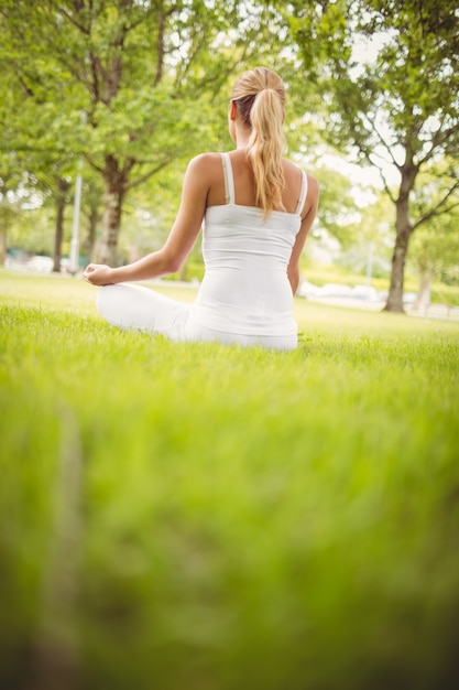 Frau meditiert im Park