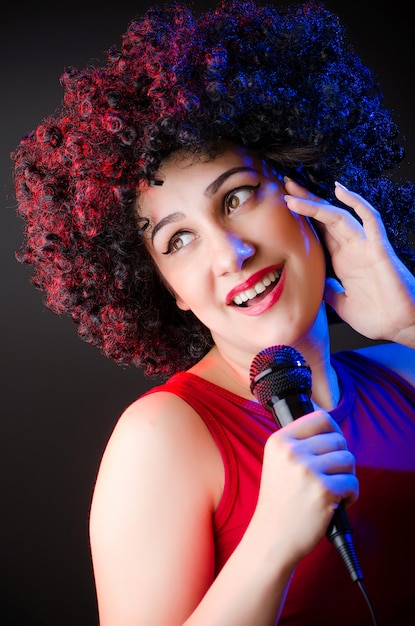 Frau mit Afrofrisur singend im Karaoke