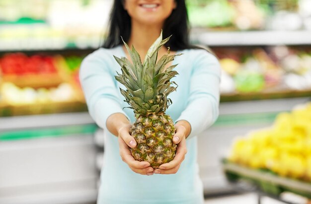 Foto frau mit ananas im lebensmittelgeschäft