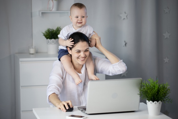 Frau mit Baby am Laptop