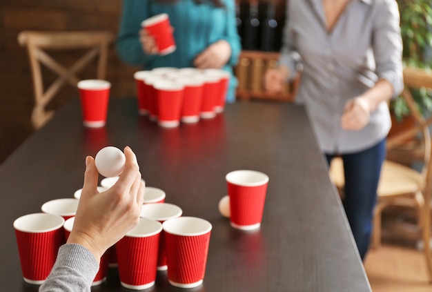 Frau mit Ball für Beer Pong-Spiel