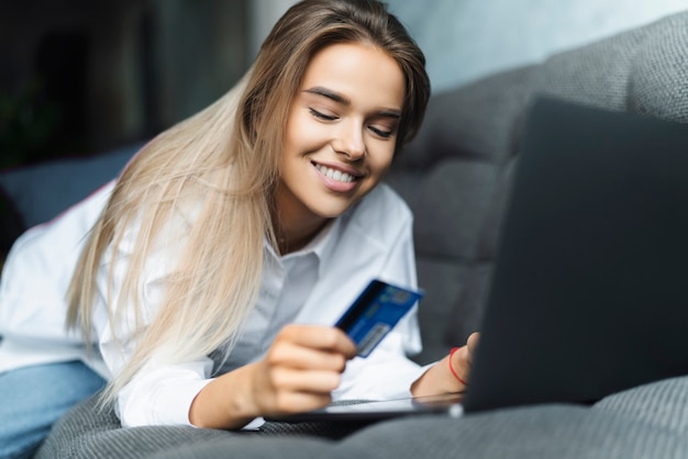 Frau mit Bankkarte, um online gekaufte Waren zu bezahlen