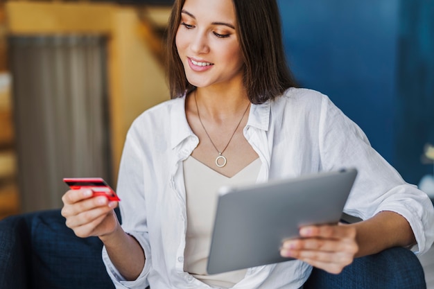 Foto frau mit bankkarte, um online gekaufte waren zu bezahlen.