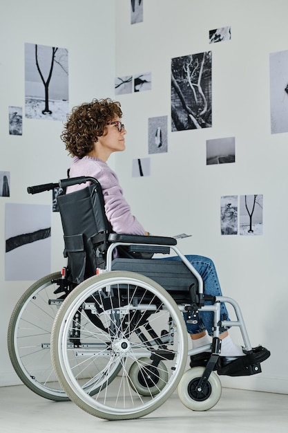 Frau mit Behinderung besucht Ausstellung