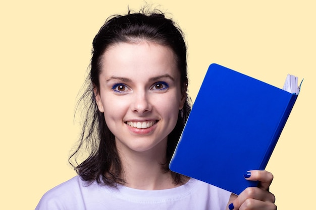 Frau mit blauem Notizbuch in ihren Händen