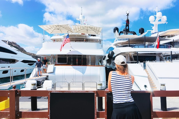 Foto frau mit blick auf die yachten in porto cervo, costa esmeralda, sardinien, italien.