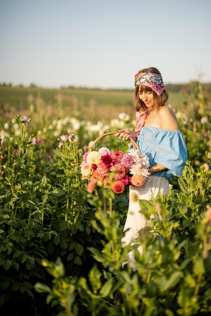 Frau mit Blumen auf Dahlienfarm im Freien