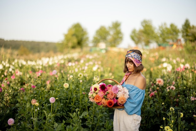 Frau mit Blumen auf Dahlienfarm im Freien