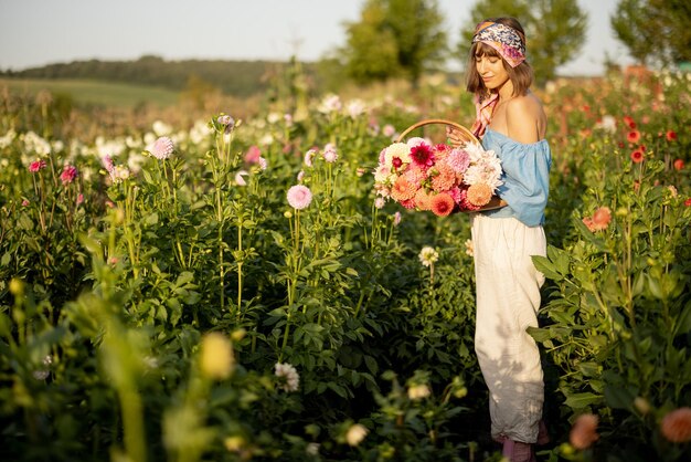 Frau mit Blumen auf Dahlienfarm im Freien