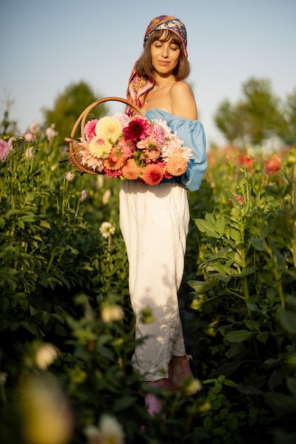 Frau mit Blumen auf Dahlienfarm im Freien