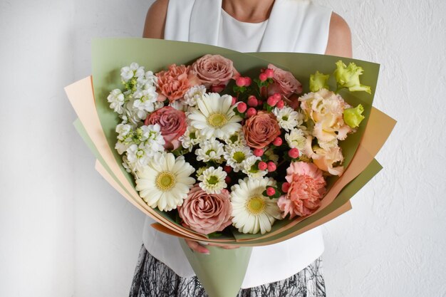 Frau mit Blumenstrauß Schöne Blumen für Urlaub Frau mit schönen Blumen in ihren Händen drinnen Hintergrund Blumenstrauß für Blumenladen