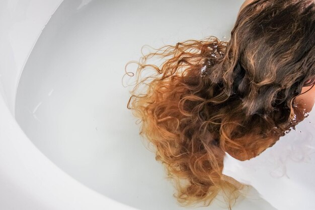 Frau mit braunen Haaren ruht in der Badewanne