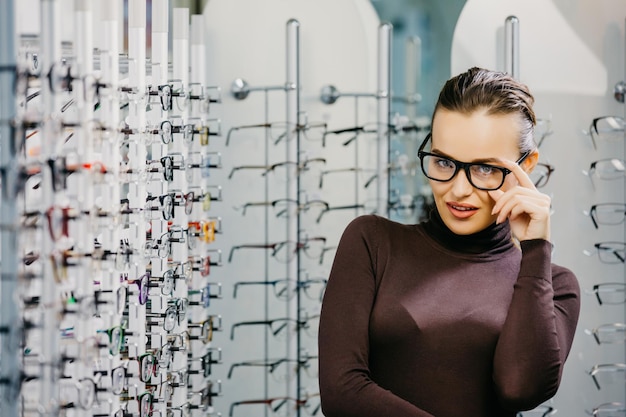 Frau mit Brille im Optikgeschäft Schönes Mädchen mit Brille im Optikergeschäft Augenheilkunde