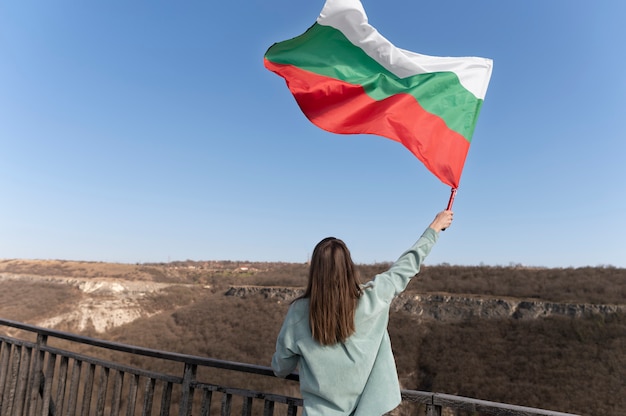 Foto frau mit bulgarischer flagge draußen