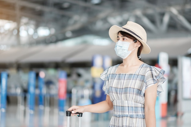 Frau mit chirurgischer Gesichtsmaske am Flughafen