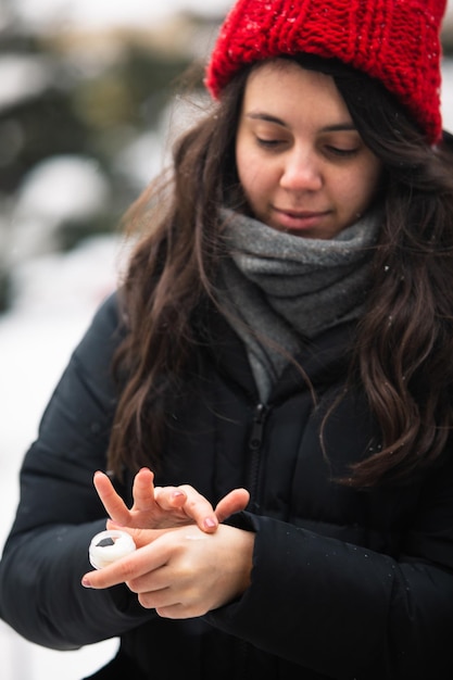 Frau mit Creme bei kaltem Winterwetter Hautschutz