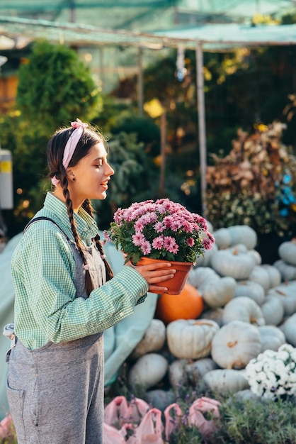 Frau mit dekorativer Blume im Blumentopf auf dem Markt