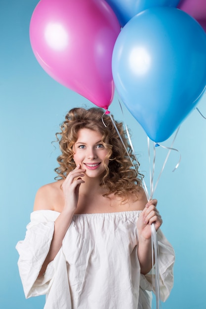 Frau mit dem gelockten Haar, das Luftballons hält