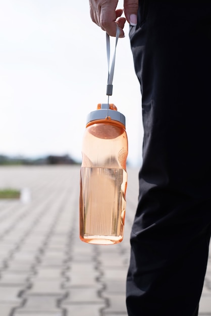 Frau mit dem Shaker in der Hand draußen im Park