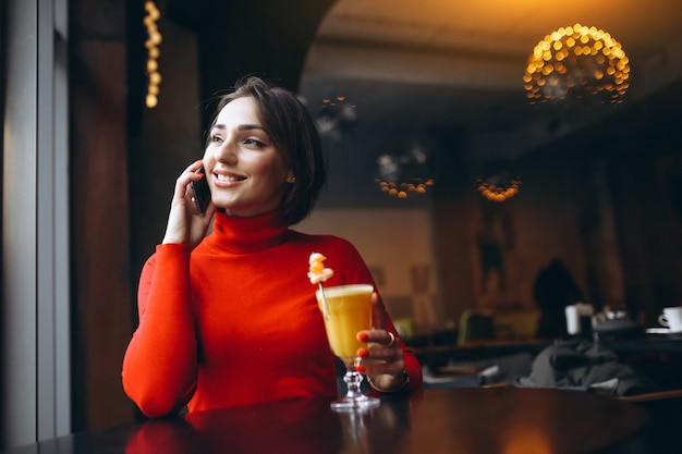 Frau mit dem Telefon, das in einem Café sitzt