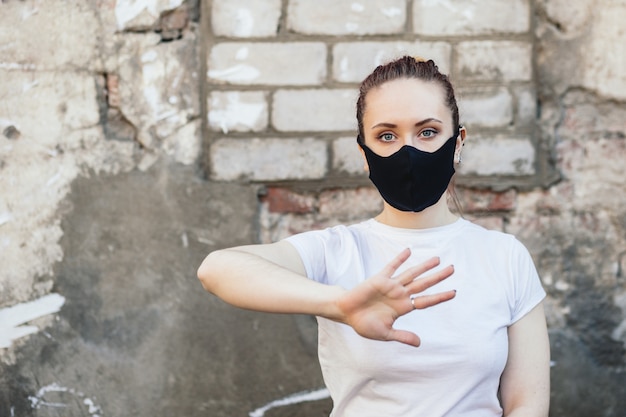 Frau mit der Hand oben in der Schutzmaske