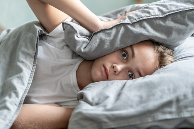 Frau mit der Schlaflosigkeit, die im Bett mit offenen Augen liegt. Am frühen Morgen. Schlaflosigkeit und Schlafstörungen. Entspannen Sie sich und schlafen Sie Konzept. Fühlt sich müde und müde. Früh aufstehen. Entspannen Sie sich und schlafen Sie Konzept.