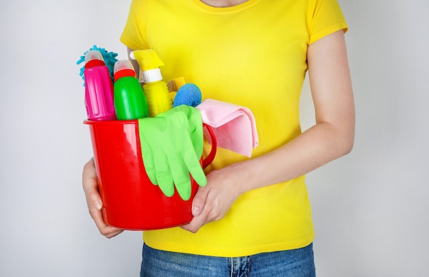 Frau mit Eimer mit Reinigungsmitteln