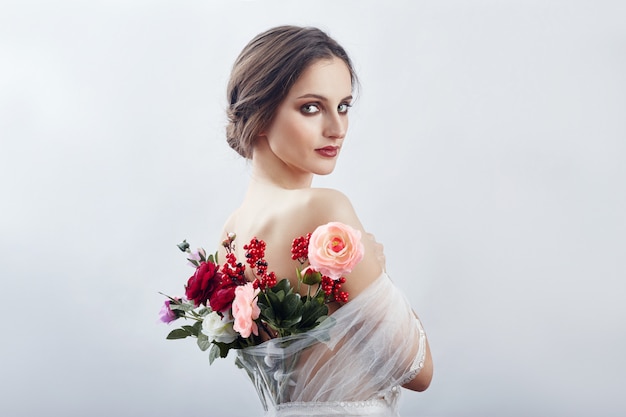 Frau mit einem Blumenstrauß von künstlichen Blumen hinten