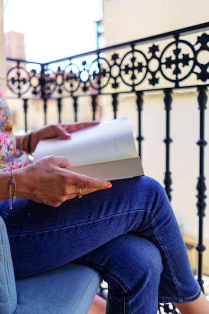 Frau mit einem Buch zum Lesen auf dem Balkon ihres Hauses Spanien Europa