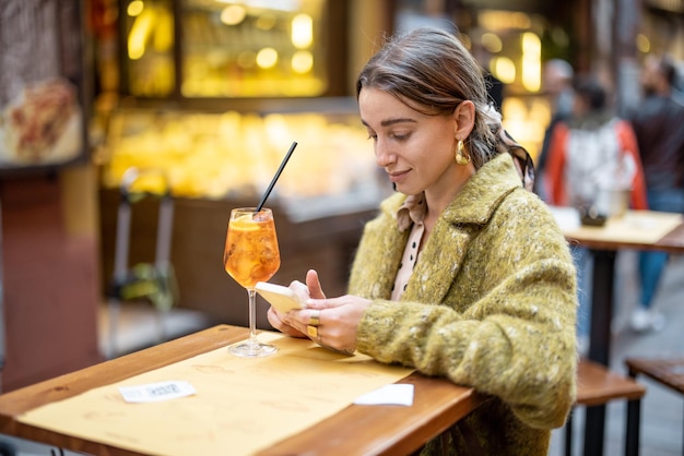 Frau mit einem Cocktail an der Bar oder im Restaurant im Freien in der Stadt Bologna