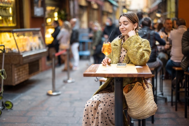 Frau mit einem Cocktail an der Bar oder im Restaurant im Freien in der Stadt Bologna