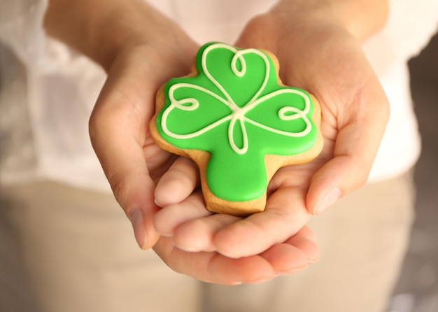 Frau mit einem dekorativen Keks zum St. Patrick's Day-Konzept