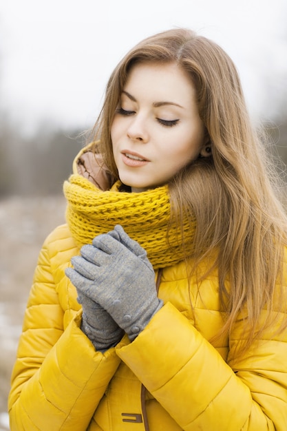 Frau mit einem gelben Strickschal draußen