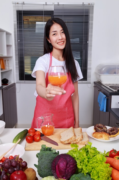 Frau mit einem Glas Orangensaft im Küchenraum