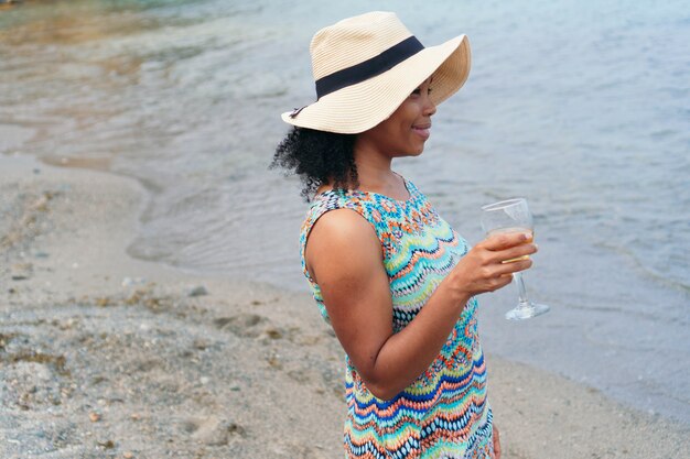 Frau mit einem Glas Wein mit dem Meer im Hintergrund